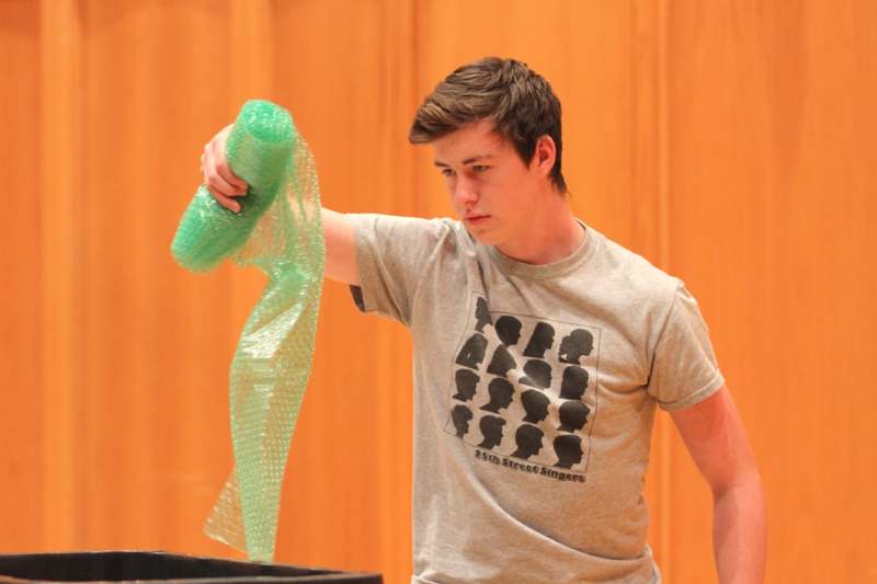 a man holding a roll of green bubble wrap