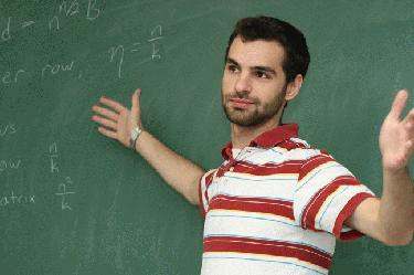 a man in a striped shirt pointing at a chalkboard