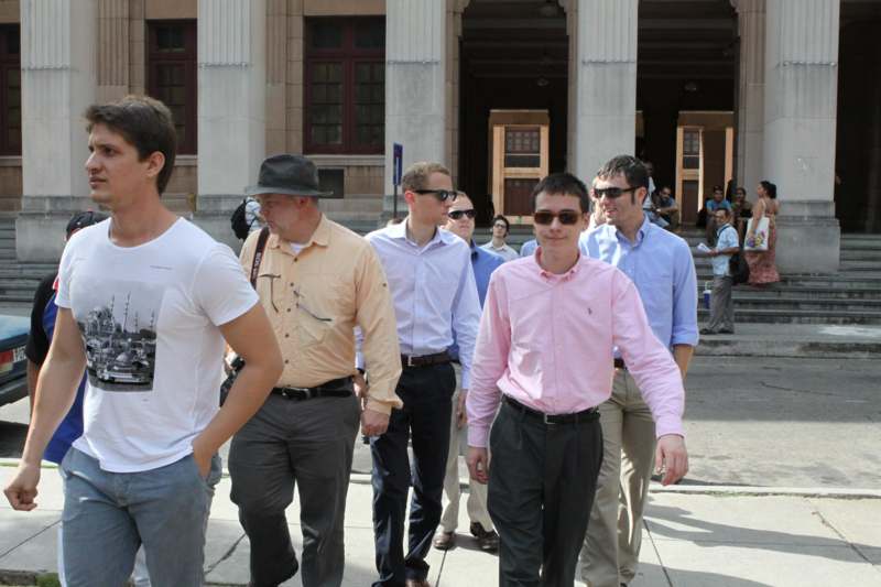 a group of men walking on a sidewalk