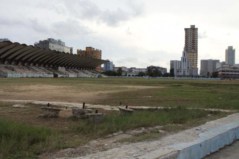 a large empty field with a large building in the background