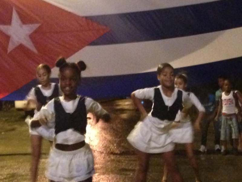 a group of girls dancing in front of a flag