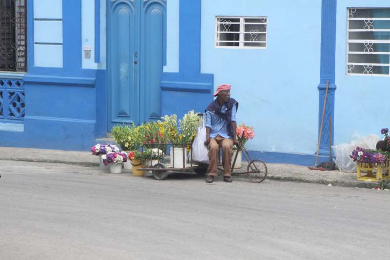 a man sitting on a bicycle with flowers on it