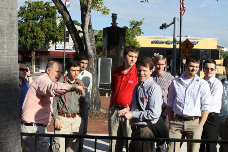 a group of men standing next to a fence