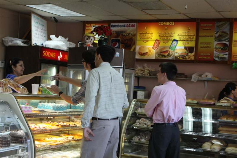 a group of men standing in a bakery