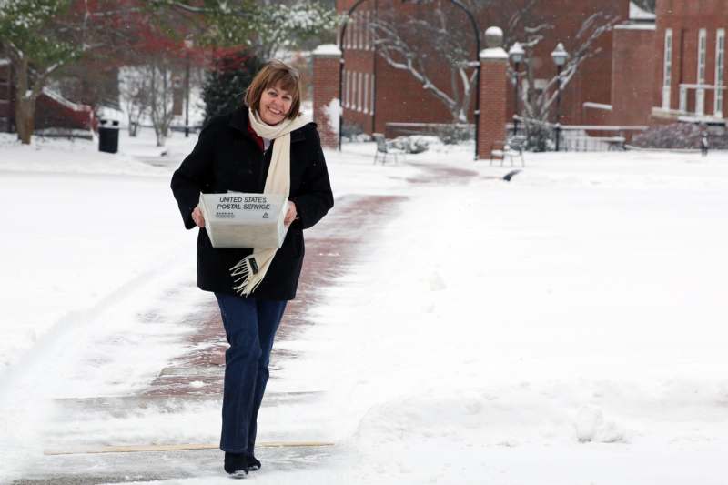 a woman carrying a box in the snow