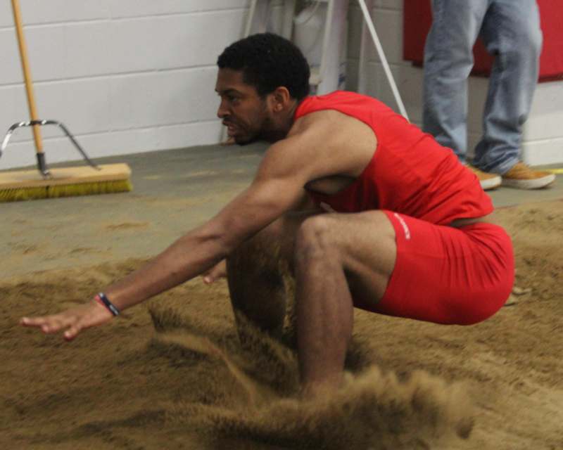 a man in red shorts jumping in dirt