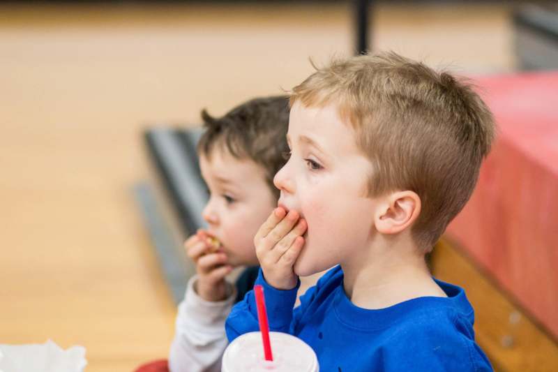 a boy eating food with his hand to his mouth