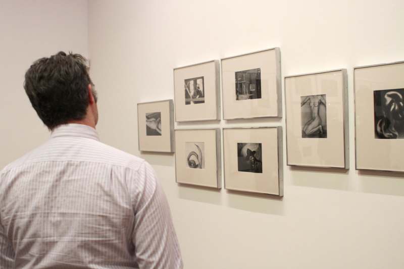 a man looking at a wall with pictures on it