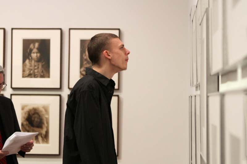 a man looking at a picture on the wall