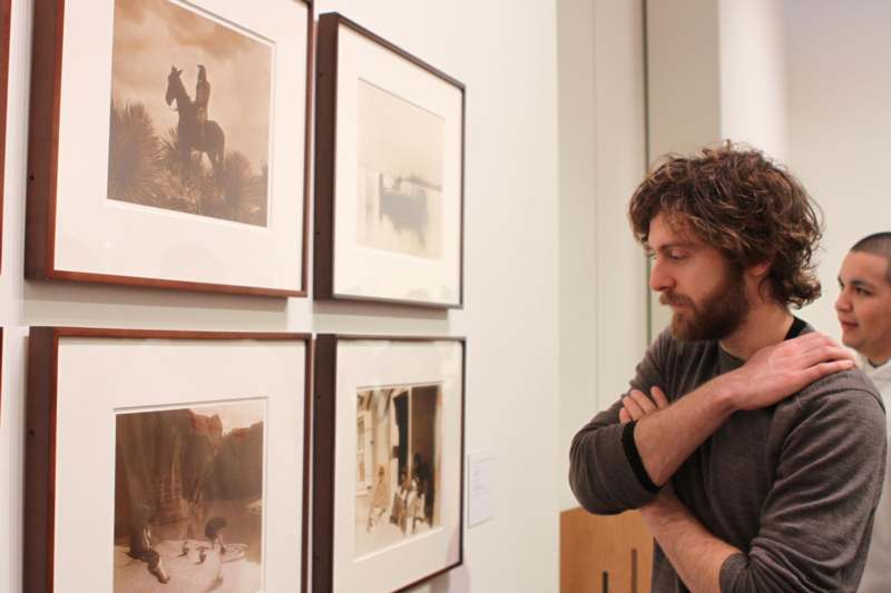 a man looking at pictures on the wall