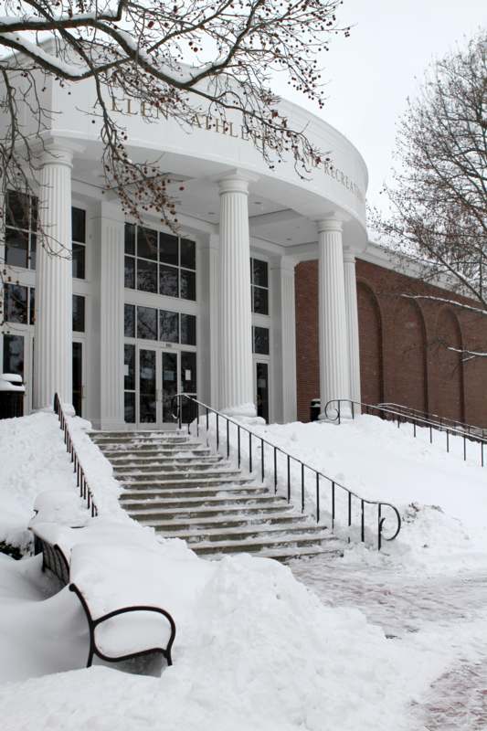 a building with a white building with columns and stairs in the snow