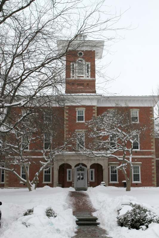 a brick building with a tower and snow