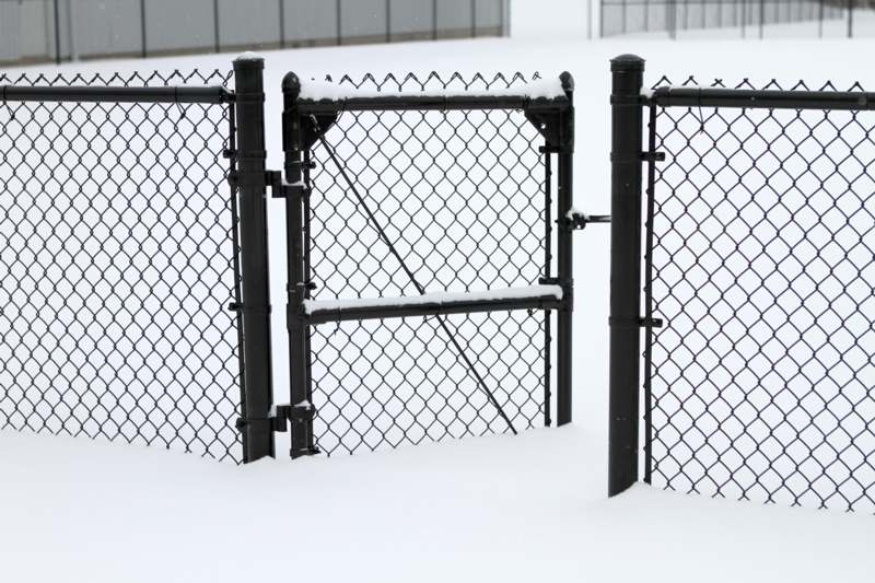 a chain link fence in the snow