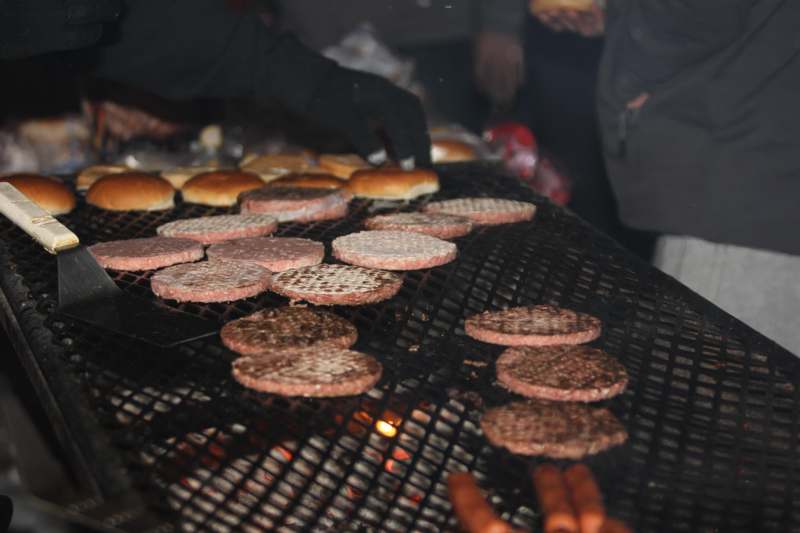 a person cooking burgers on a grill