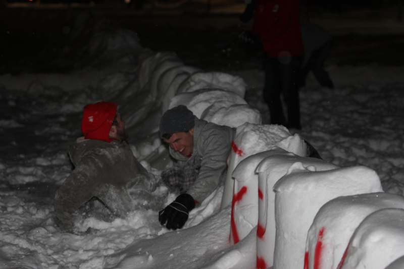 a group of men lying in snow