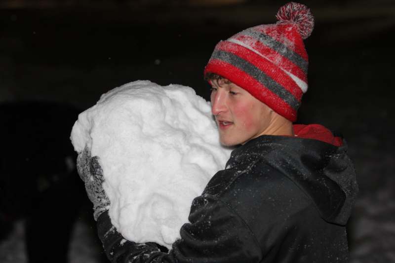 a man holding a large snowball