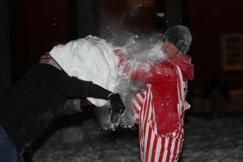 a person in a red and white striped outfit throwing snow