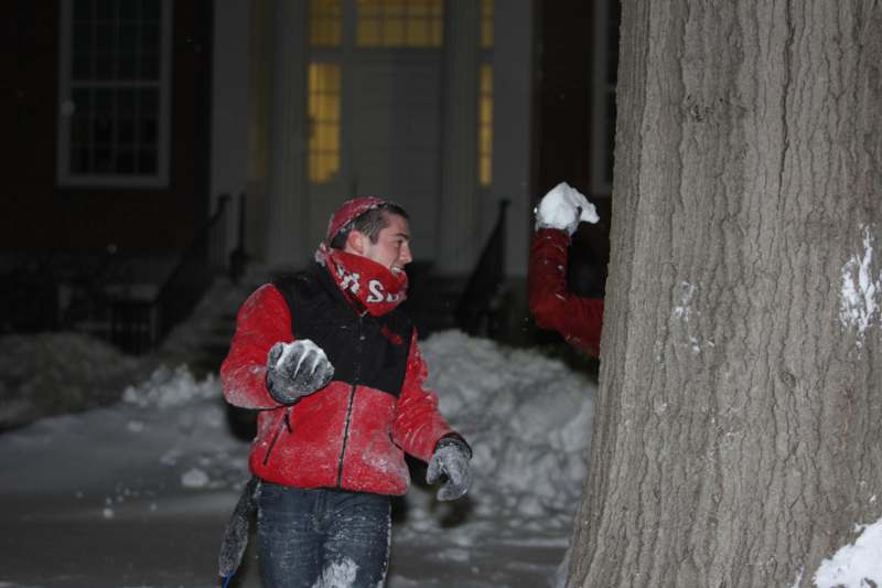 a man in a red jacket throwing snowball