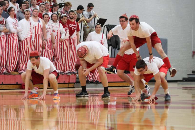 a group of men in white shirts and red shorts on a basketball court