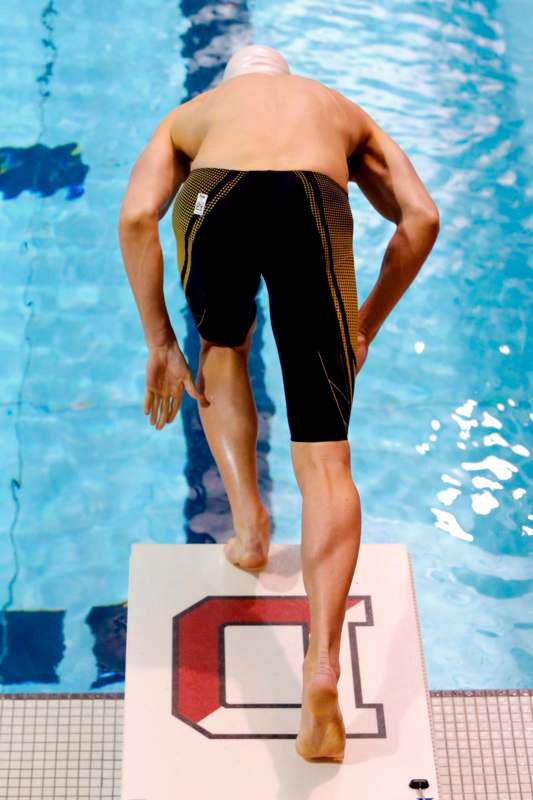 a man in a swimming suit jumping into a pool