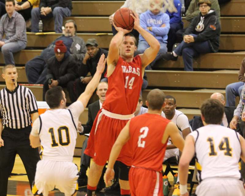 a basketball player in red uniform jumping to shoot a ball