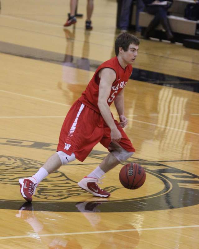 a man in red uniform dribbling a basketball