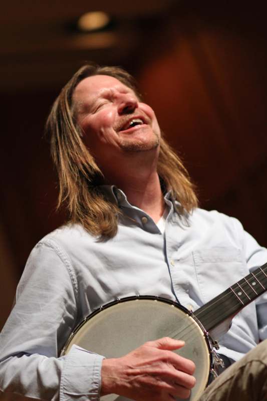a man with long hair and a banjo
