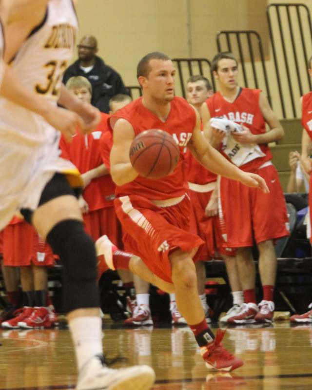 a man in red uniform running with a basketball