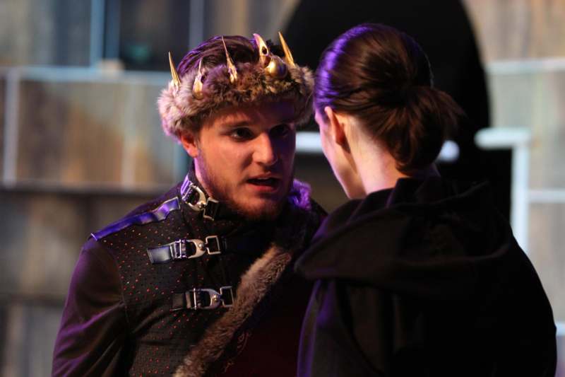 a man wearing a crown and a woman looking at him