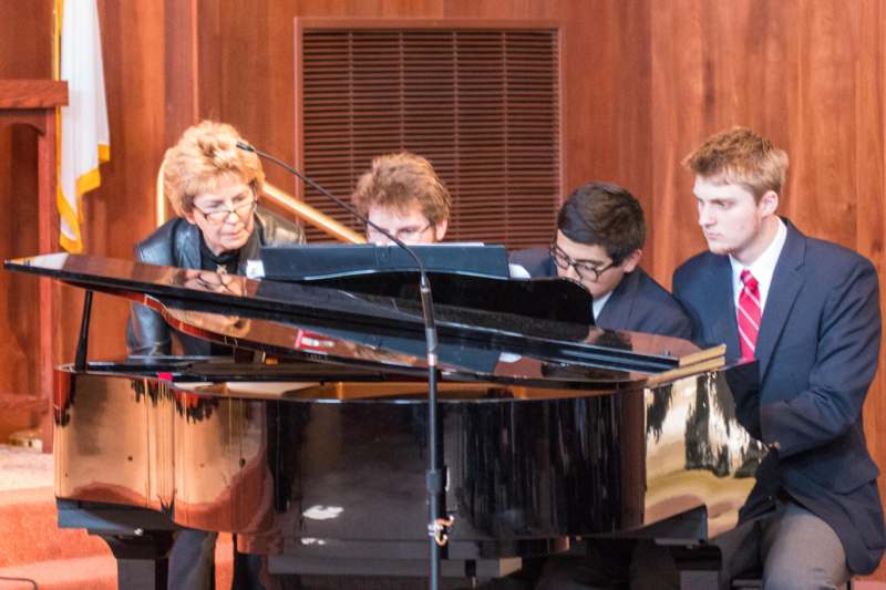 a group of people playing piano