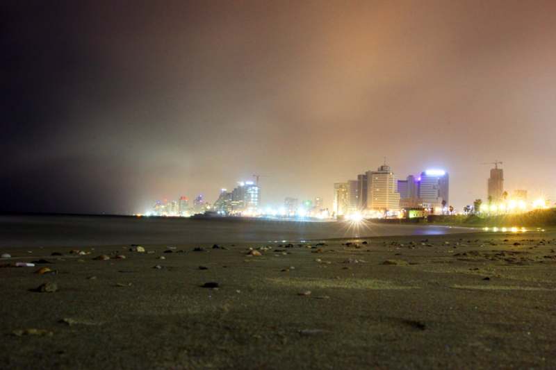 a beach with buildings and lights at night