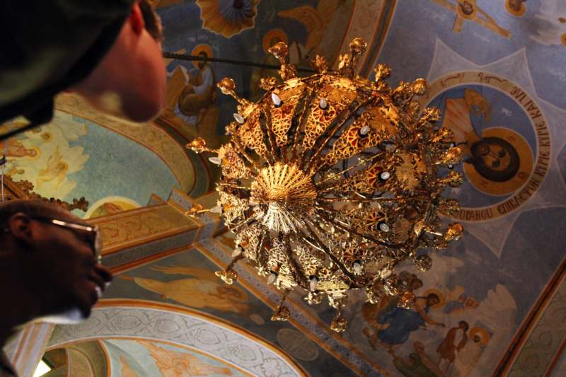 a person looking at a gold chandelier