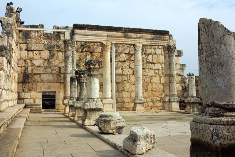 a stone building with columns with Capernaum in the background