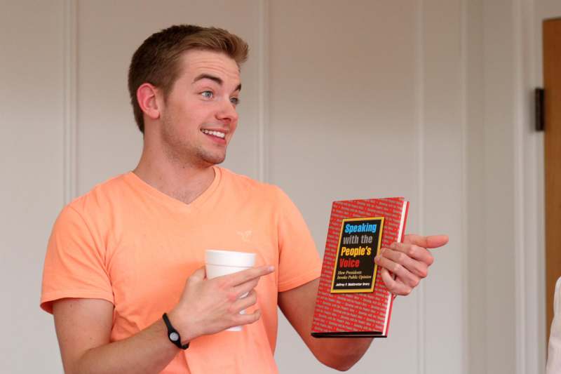 a man holding a book and a cup