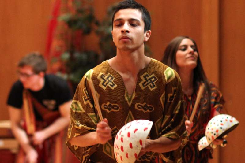 a man in a dress holding drumsticks