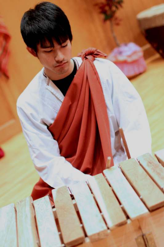 a man in a robe playing xylophone