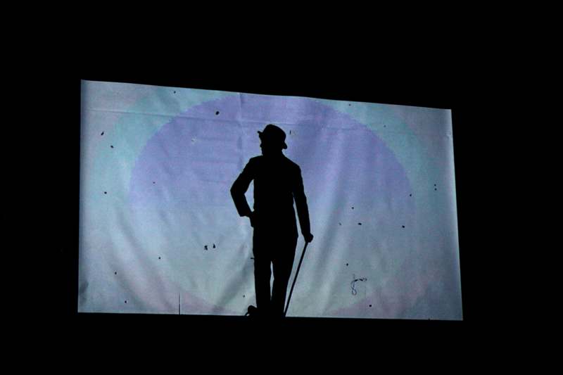 a silhouette of a man walking on a stage