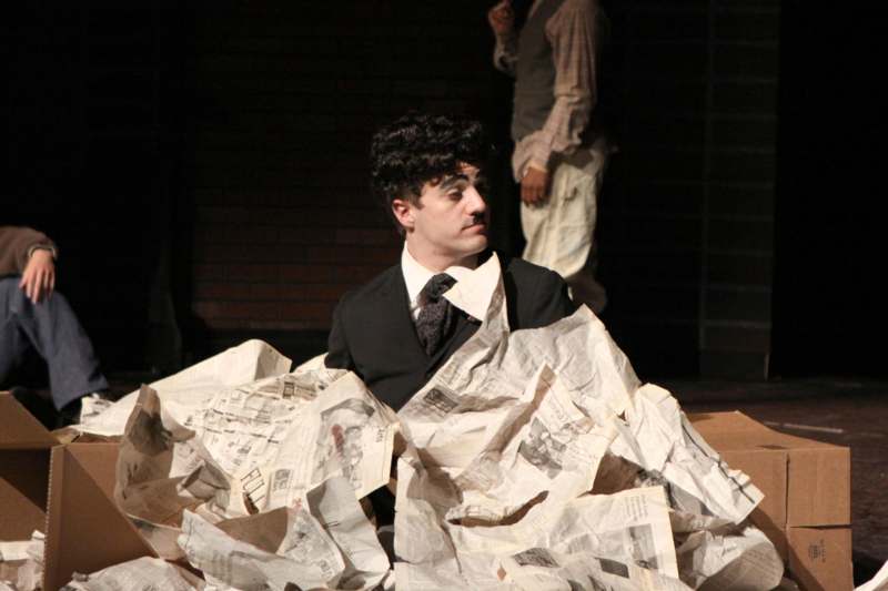 a man sitting in a pile of newspapers