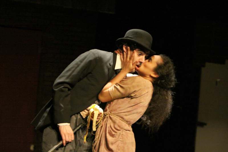 a man and woman kissing on a stage