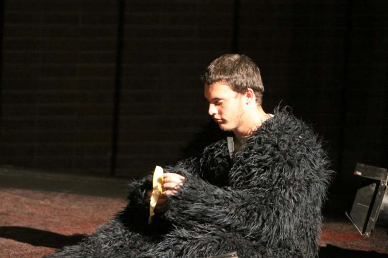 a man in a furry coat eating a banana
