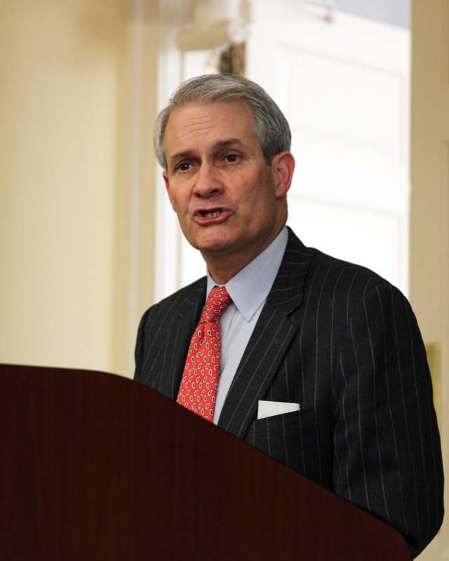a man in a suit speaking at a podium