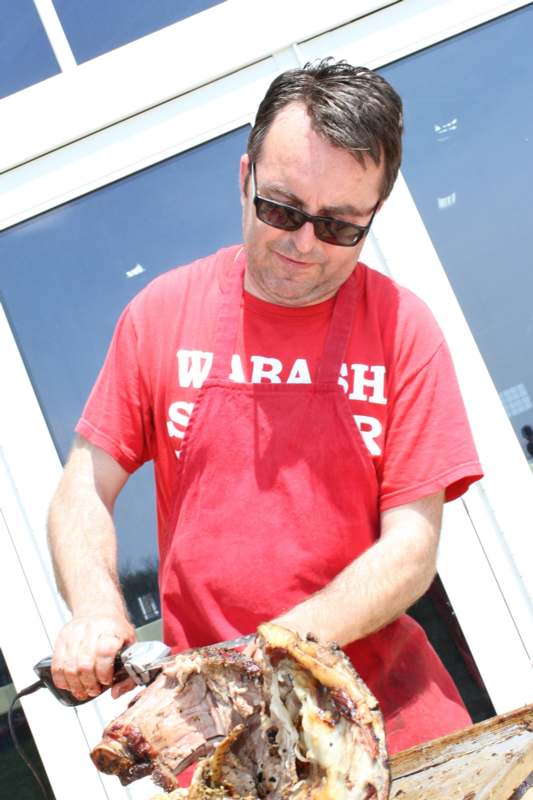 a man wearing sunglasses and a red shirt holding a grill