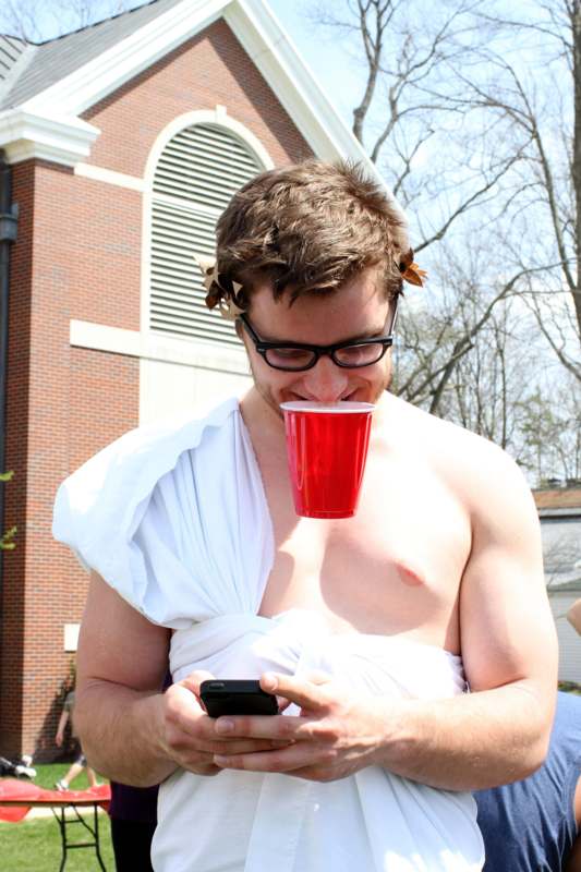 a man wearing a toga and drinking from a red cup