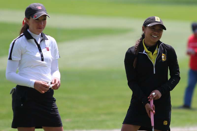 two women standing on a golf course