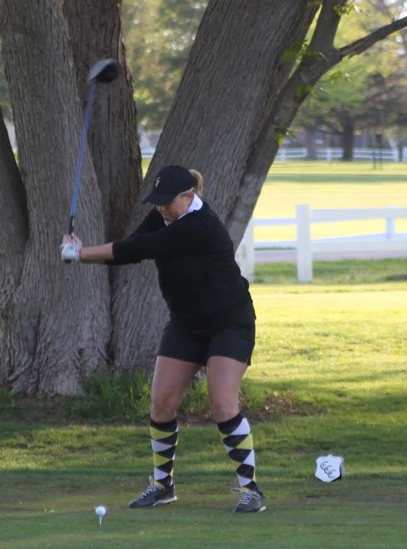 a woman swinging a golf club