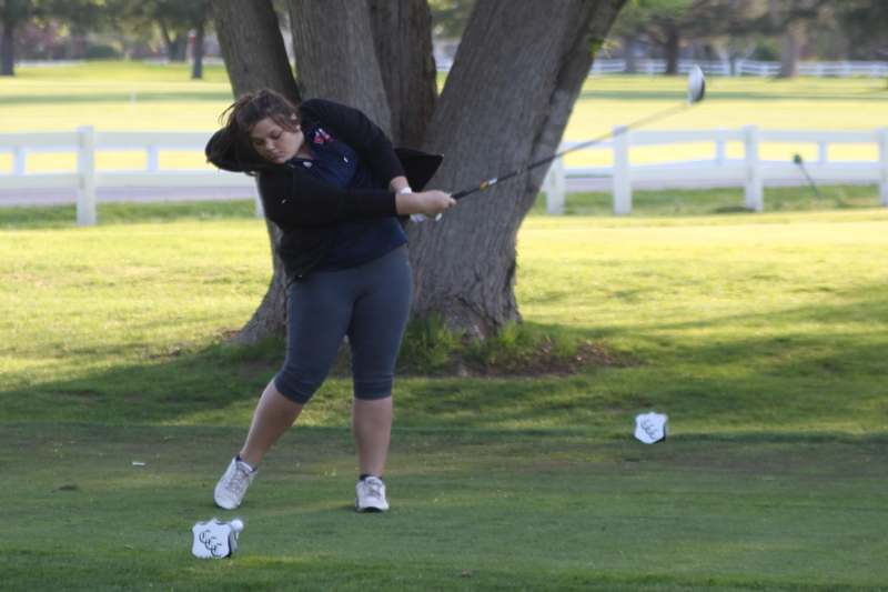 a woman swinging a golf club