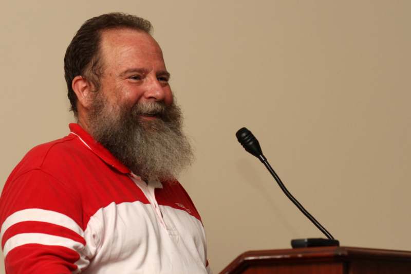 a man with a beard standing at a podium