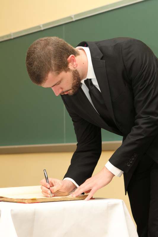 a man in a suit writing on a piece of paper
