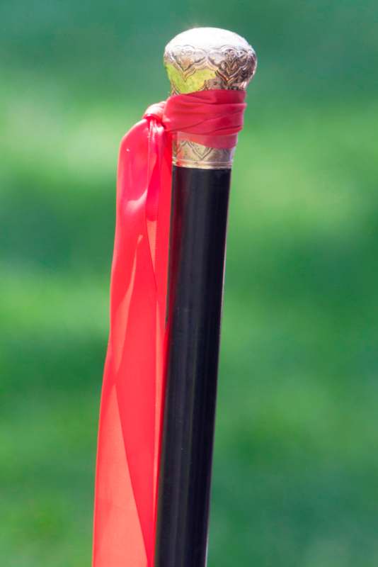 a black stick with a red ribbon tied to it