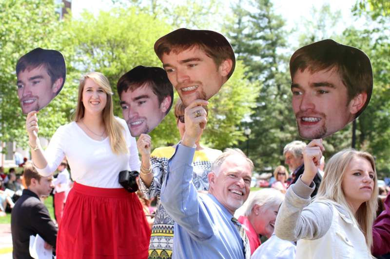 a group of people holding up cardboard faces